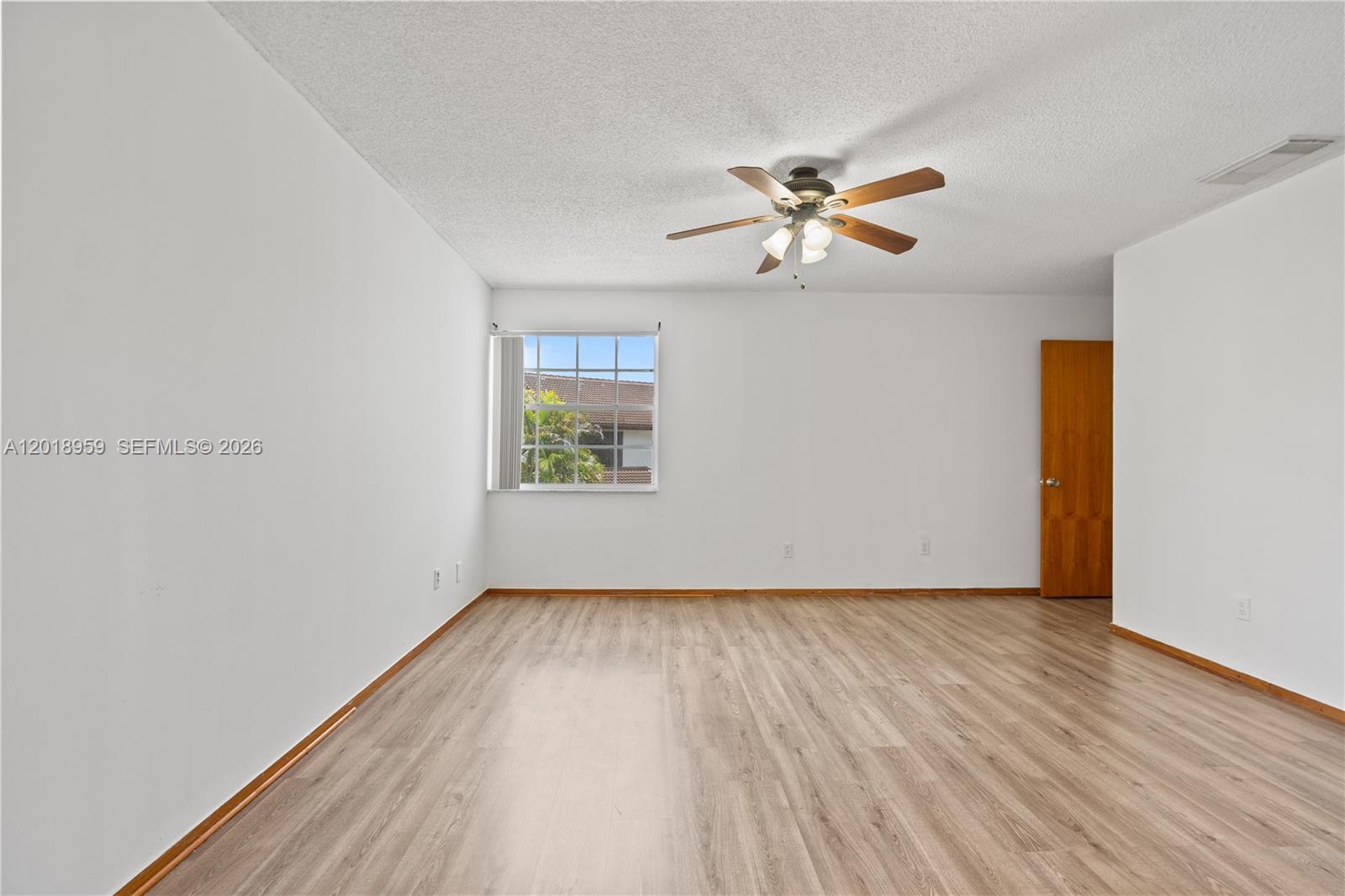 15345 Southwest 63rd Terrace Miami, FL 33193 - Photo 17 of 51 an empty room with wooden floor fan and windows