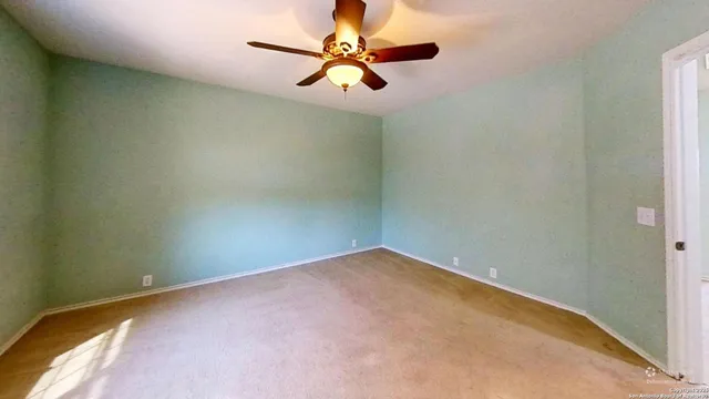 an empty room with a window and a fan