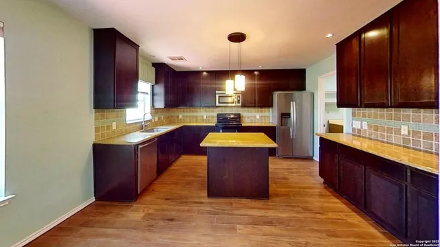 a kitchen with wooden cabinets and stainless steel appliances