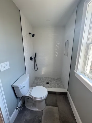 a white toilet sitting next to a bathroom sink and shower