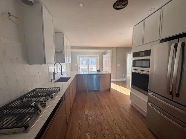 a kitchen with kitchen island granite countertop a stove and a refrigerator
