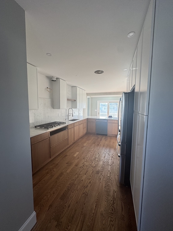 12 Bronx Road Boston, MA 02132 - Photo 3 of 31 a large kitchen with a refrigerator and wooden floor