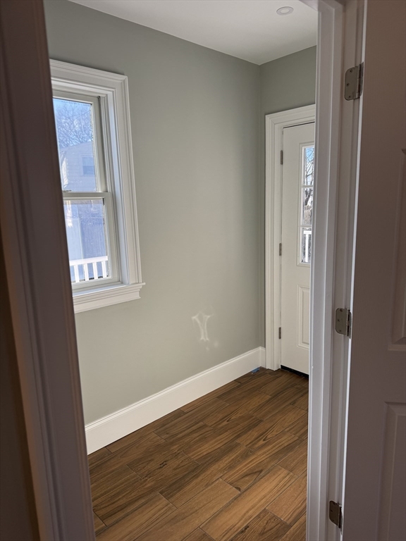 12 Bronx Road Boston, MA 02132 - Photo 5 of 31 a view of an empty room with wooden floor and a window