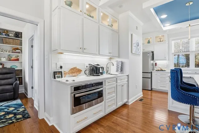 a kitchen with stainless steel appliances white cabinets and a stove top oven