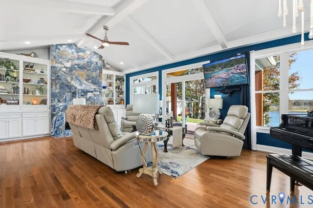 a living room with furniture large window and wooden floor