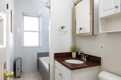 a bathroom with a granite countertop sink and a mirror