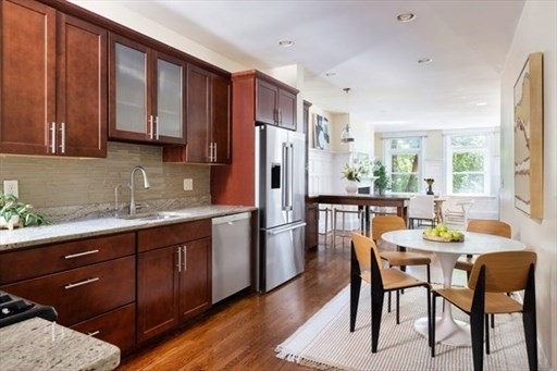 1898 Beacon Street, Unit 4 Brookline, MA 02445 - Photo 7 of 13 a kitchen with stainless steel appliances granite countertop wooden floor cabinets and a refrigerator