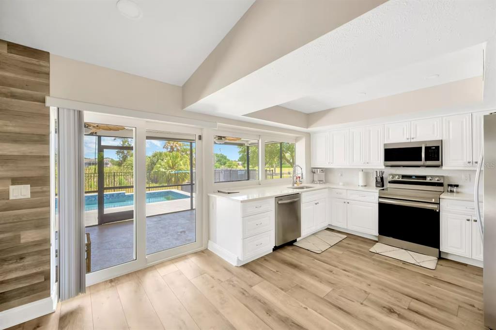 721 Eagle Lane Apollo Beach, FL 33572 - Photo 12 of 48 a kitchen with a stove a sink and a refrigerator