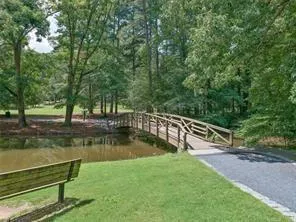 a view of a lake with a bench and trees around