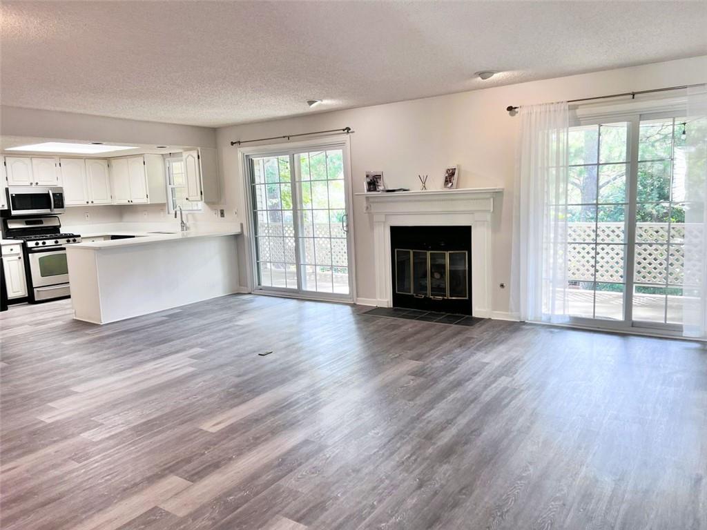 23 Chelsea Court Avondale Estates, GA 30002 - Photo 6 of 25 a view of a living room a kitchen with a fireplace and wooden floor