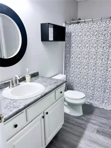 a bathroom with a granite countertop toilet sink and mirror