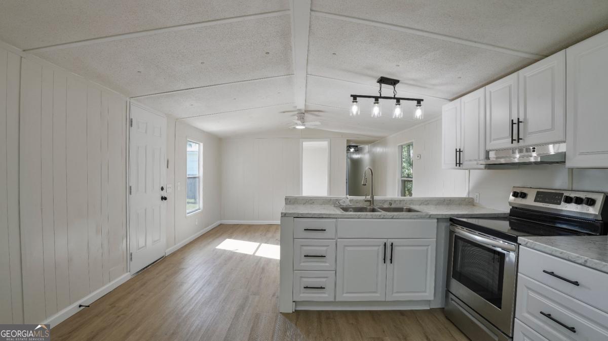 50 Sangster Road Jesup, GA 31545 - Photo 13 of 22 a kitchen with kitchen island granite countertop a sink cabinets and stainless steel appliances