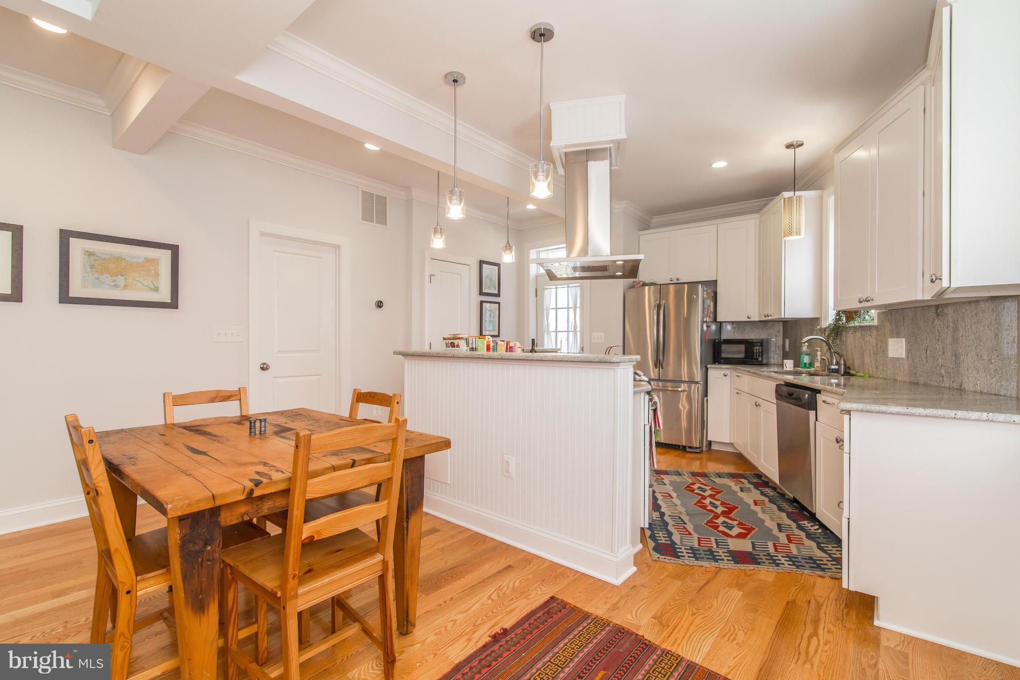 1849 3rd Street Northwest Washington, DC 20001 - Photo 6 of 23 a kitchen with stainless steel appliances kitchen island granite countertop a table chairs and a refrigerator