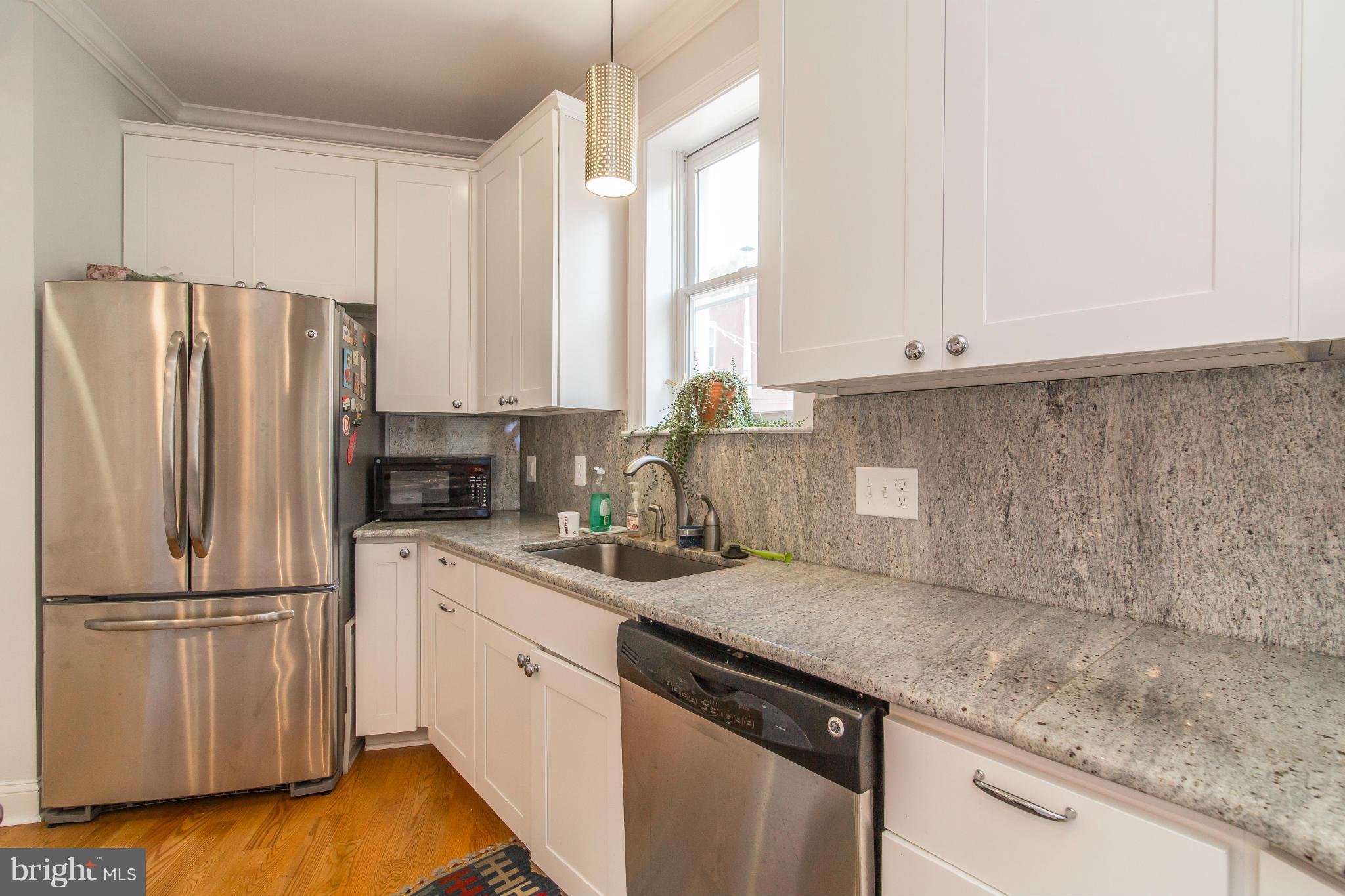 1849 3rd Street Northwest Washington, DC 20001 - Photo 9 of 23 a kitchen with a sink a refrigerator and white cabinets