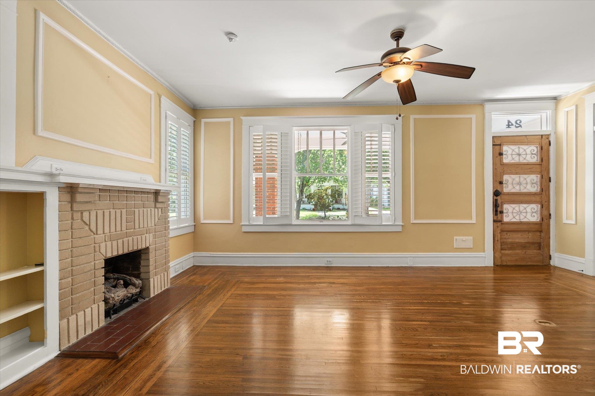 24 Macy Place Mobile, AL 36604 - Photo 7 of 38 Unfurnished living room featuring a ceiling fan, a fireplace, wood finished floors, and baseboards