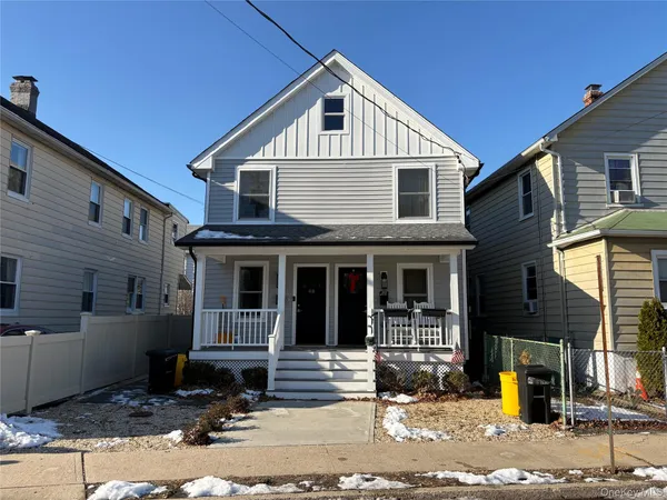 a view of a house with street next to a yard