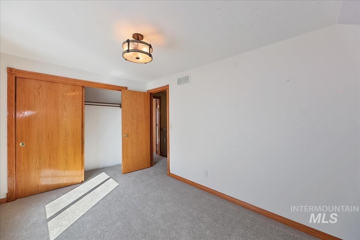 2804 West Sunrise Rim Road Boise, ID 83705 - Photo 35 of 50 Neutral wall paint with contrasting wood-finish trim, a flush-mount light fixture, and gray carpeting