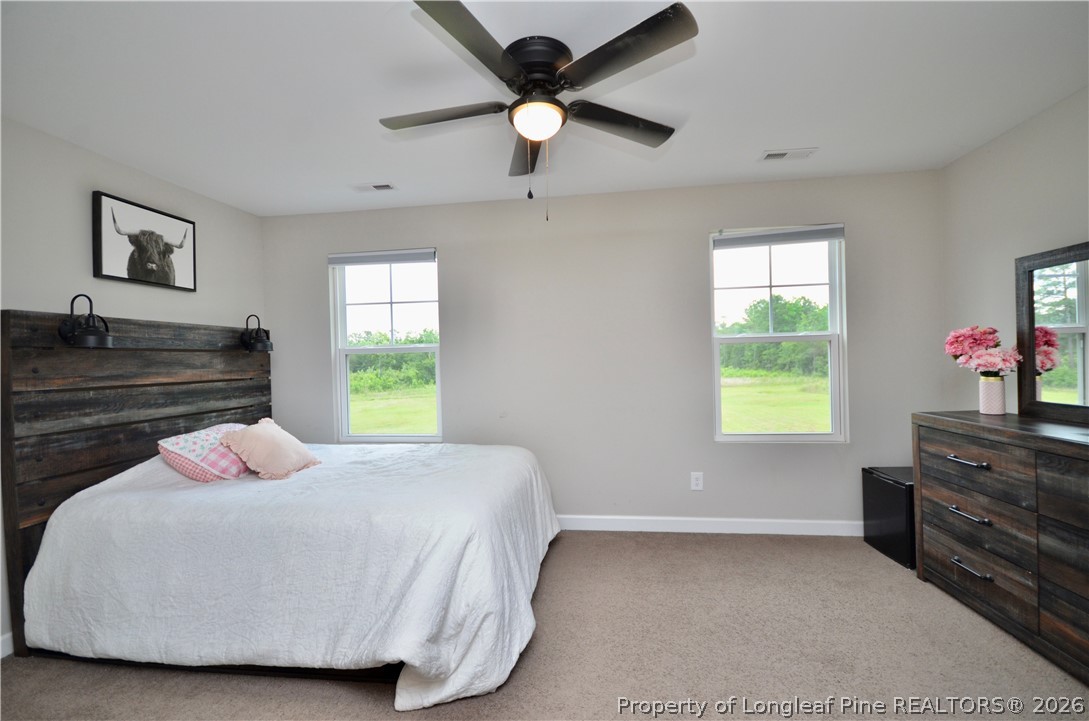 1865 John B Carter Road Fayetteville, NC 28312 - Photo 32 of 49 a bedroom with a bed and a chandelier