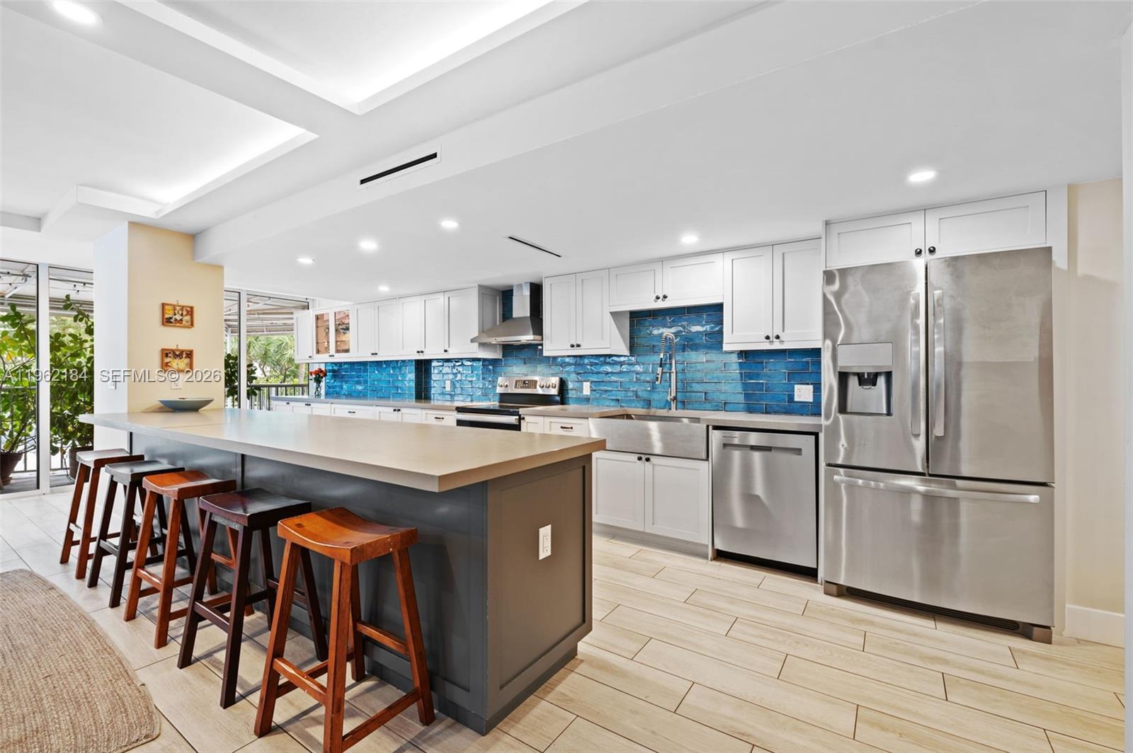 600 Grapetree Drive, Unit 3DS Key Biscayne, FL 33149 - Photo 6 of 33 a kitchen with stainless steel appliances granite countertop a table chairs sink refrigerator and microwave