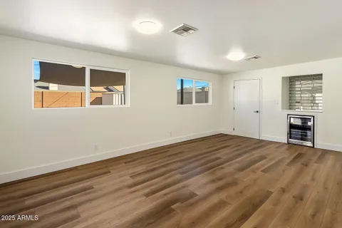a view of an empty room with a window and wooden floor