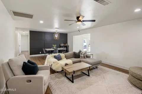 a living room with furniture and a ceiling fan