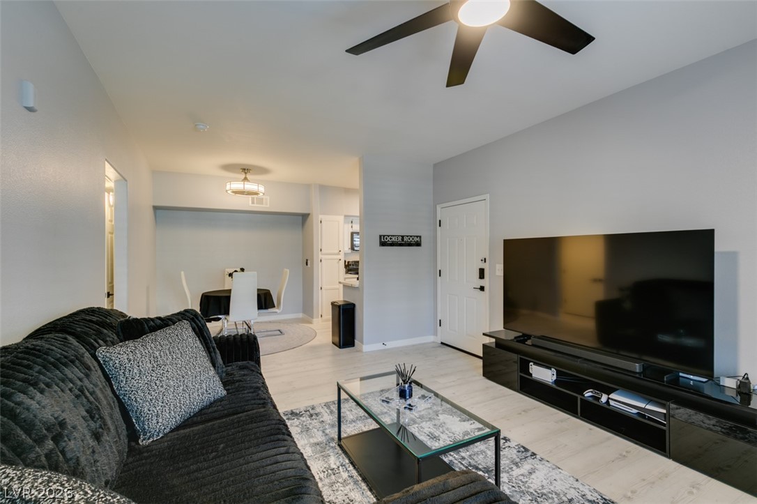 7255 West Sunset Road, Unit 1103 Las Vegas, NV 89113 - Photo 17 of 35 An inviting open-concept living space features light wood flooring and a modern ceiling fan, creating an airy ambiance.