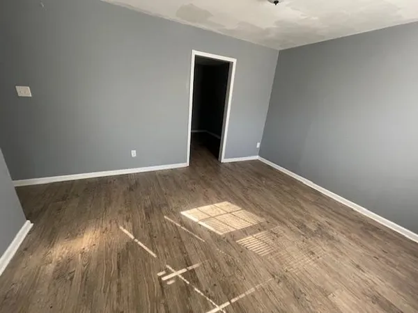 a view of a room with wooden floor and white walls