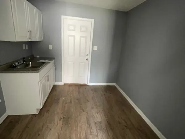 a kitchen with a sink and wooden floor