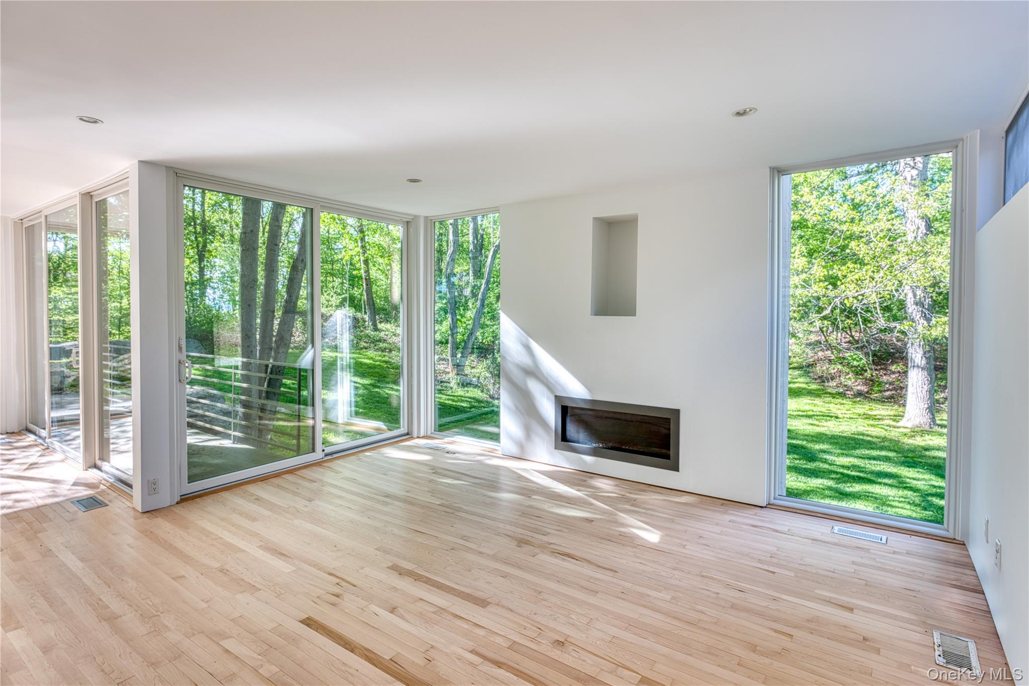61 Indian Brook Road Garrison, NY 10524 - Photo 7 of 23 a view of an empty room with wooden floor and a window