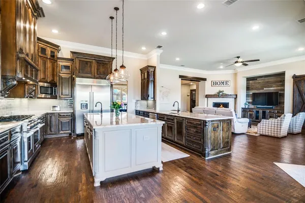 a large kitchen with stainless steel appliances granite countertop a lot of counter space and wooden floors