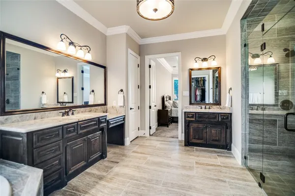 a large bathroom with a granite countertop double vanity sink a mirror and shower