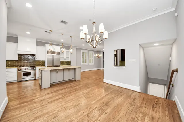 a large kitchen with granite countertop a large counter top a sink stainless steel appliances and cabinets