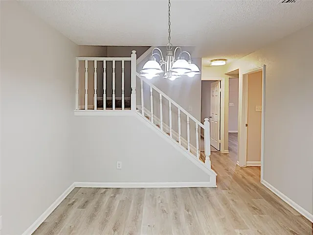 a view of a livingroom with wooden floor and stairs