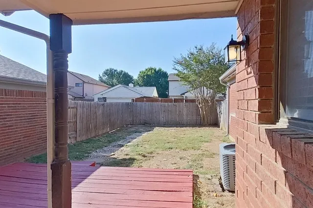 a view of a house with a yard and wooden fence