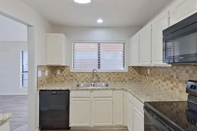 a kitchen with stainless steel appliances granite countertop a sink stove and cabinets