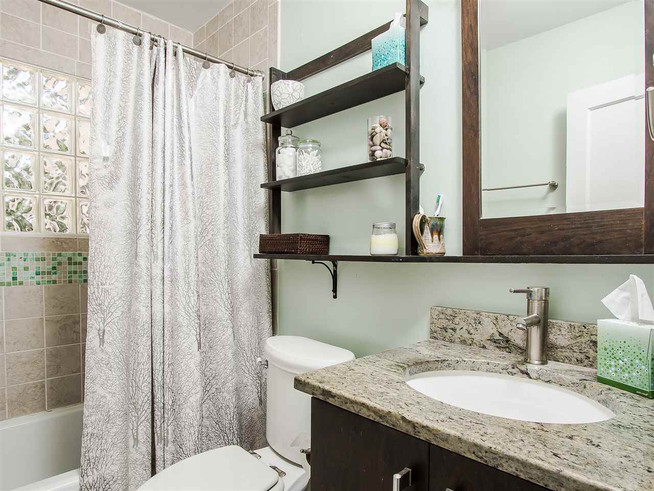 1634 Bickett Boulevard Raleigh, NC 27608 - Photo 18 of 25 No detail was left undone in this tub/shower combination bath. It is complete with ceramic/glass walls and floors, glass block window and high-end vanity and fixtures. Bath