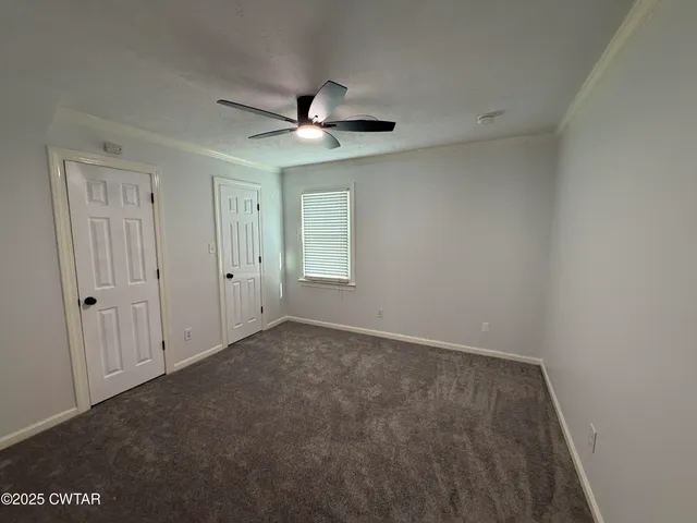 an empty room with a window and a ceiling fan