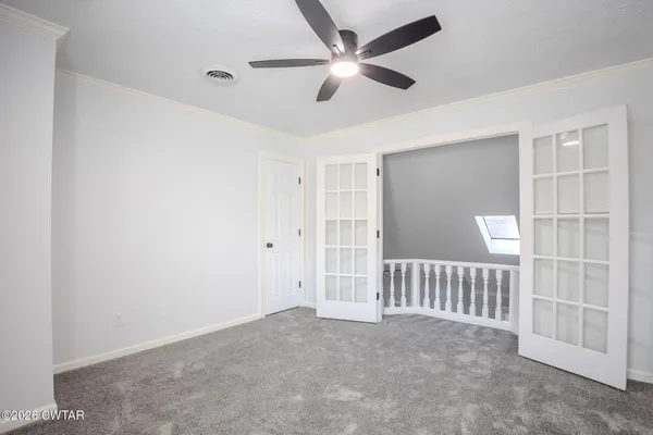 an empty room with a ceiling fan and a window