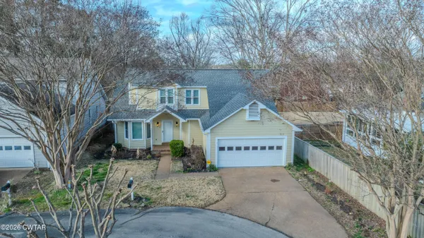 a view of a house with a yard and wooden fence