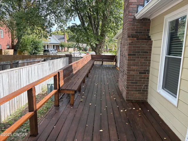 a view of balcony with wooden floor and fence