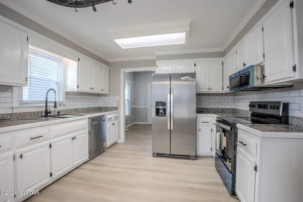 a kitchen with stainless steel appliances a refrigerator sink and microwave