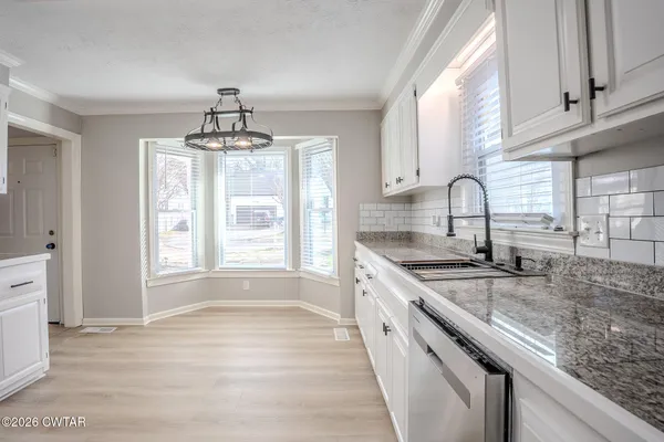 a kitchen with a sink stove and cabinets