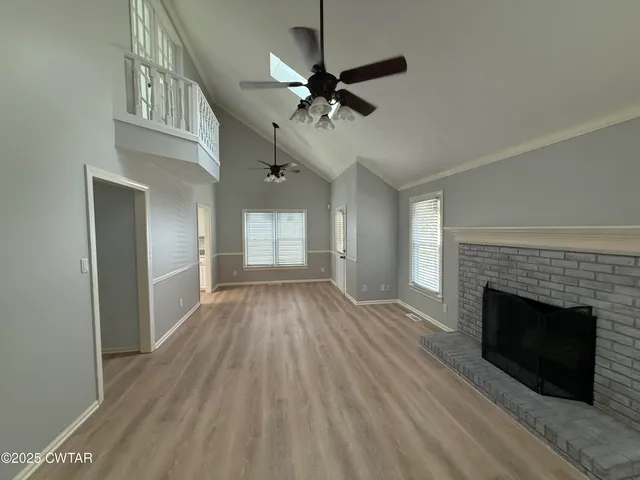 a view of an empty room with a fireplace and a window