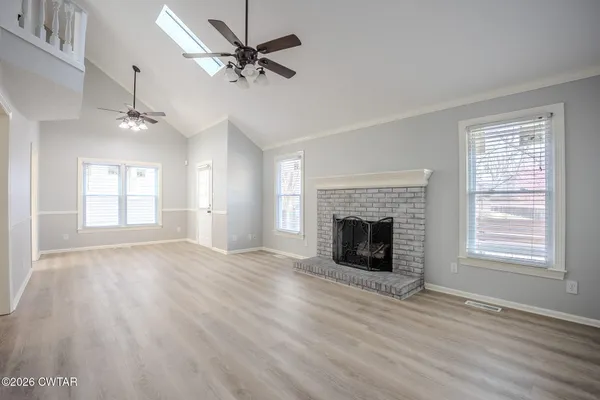wooden floor fireplace and windows in an empty room