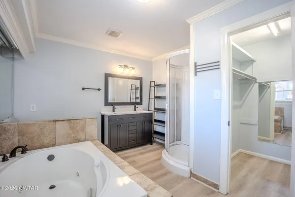 a bathroom with a tub sink and mirror
