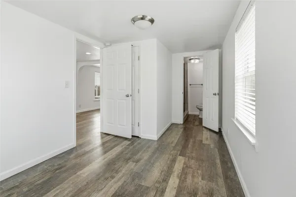 a view of a livingroom with wooden floor and a bathroom