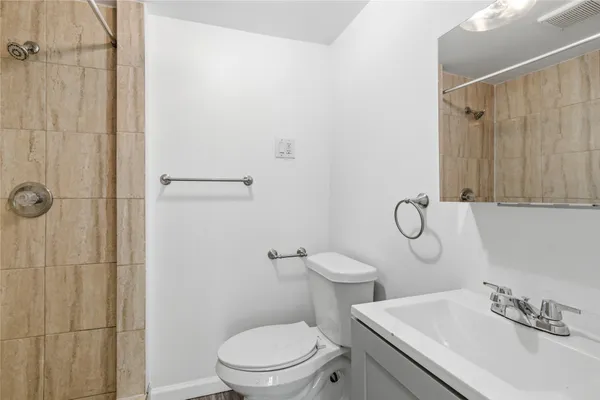 a bathroom with a sink a toilet and shower