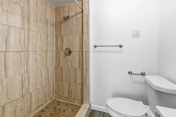 a white toilet sitting next to a shower