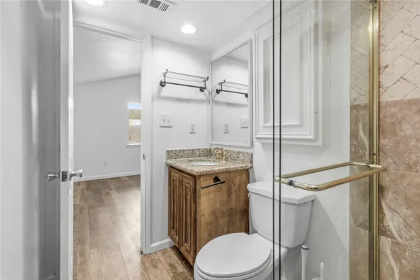 a bathroom with a granite countertop sink toilet and shower
