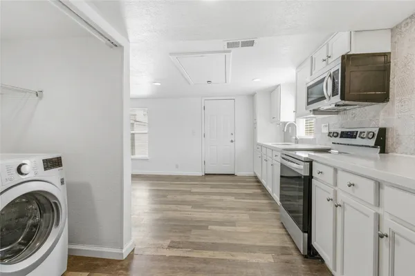 a view of a kitchen with stainless steel appliances kitchen island granite countertop a sink and a stove top oven